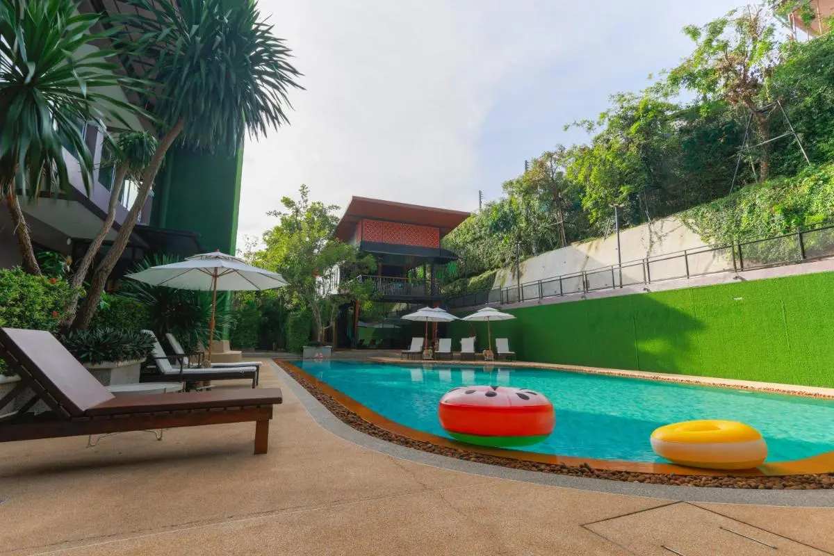 Outdoor Rectangular Swimming Pool with Lounge Chairs and Tropical Greenery in Ban Bo Rae
