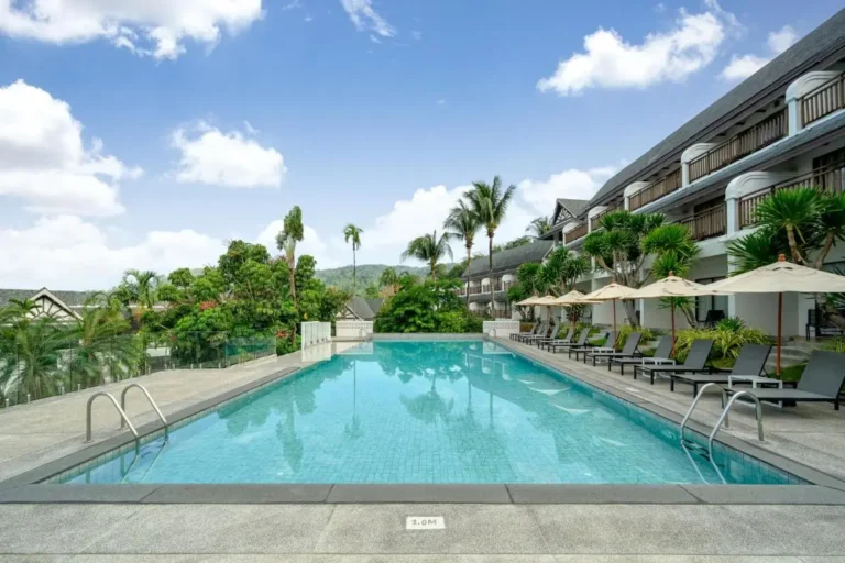Outdoor Rectangular Swimming Pool with Lounge Chairs and Tropical Landscaping at Patong Beach