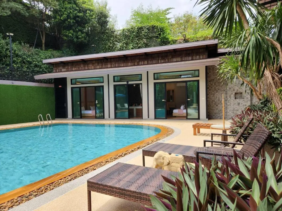 Outdoor Rectangular Swimming Pool with Lounge Seating and Natural Surroundings in Ban Bo Rae