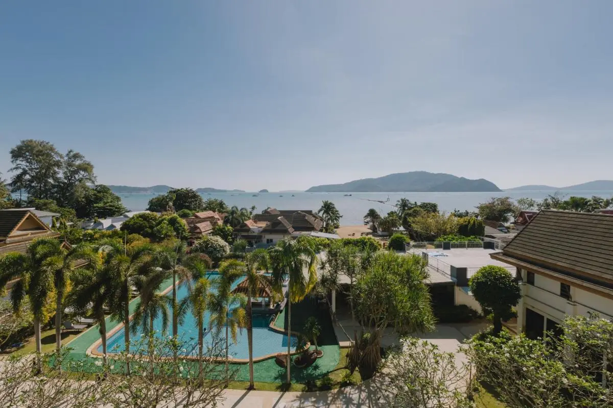 Outdoor Rectangular Swimming Pool with Palm Trees and Scenic Coastal Views at Rawai Beach