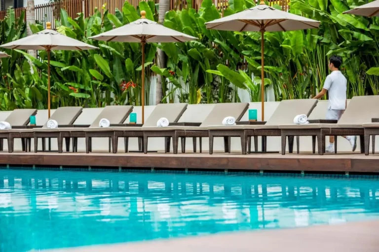 Outdoor Swimming Pool and Lounge Area with Cushioned Chairs and Umbrellas in Sathorn Outdoor Swimming Pool and Lounge Area with Cushioned Chairs and Umbrellas in Sathorn