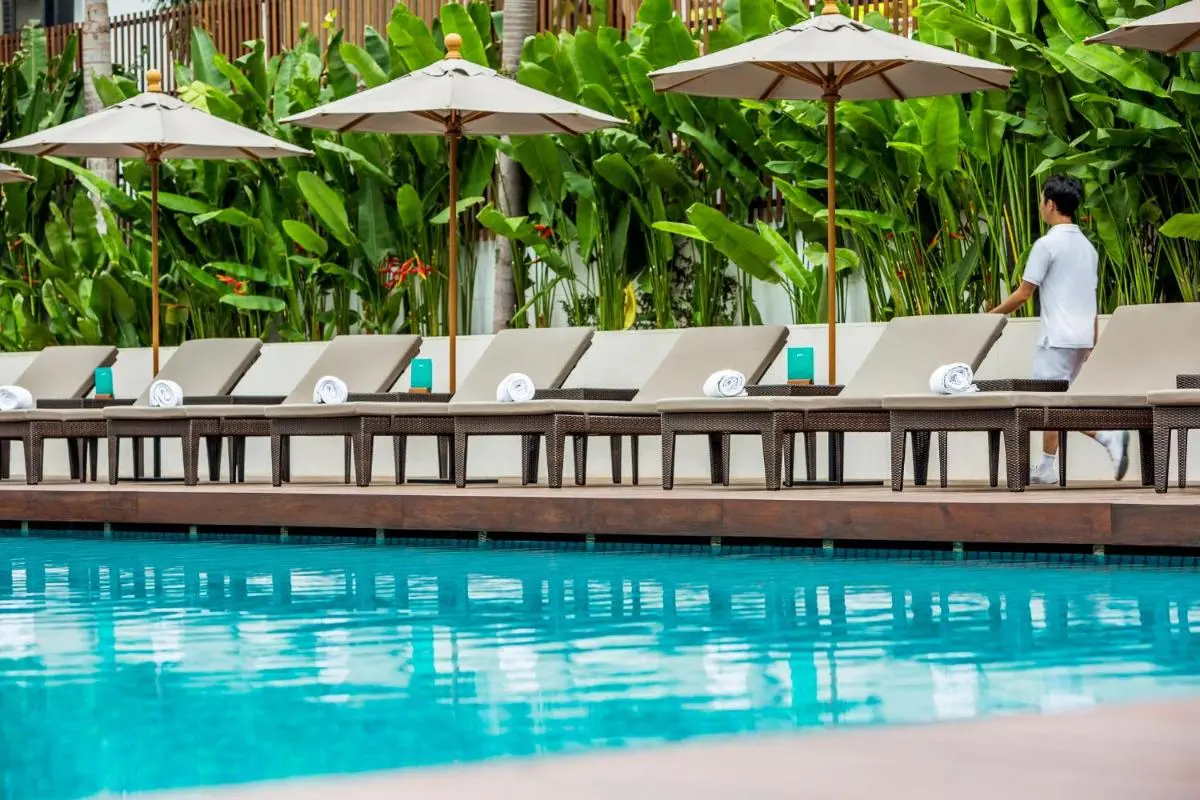 COMO Metropolitan Bangkok Outdoor Swimming Pool and Lounge Area with Cushioned Chairs and Umbrellas in Sathorn
