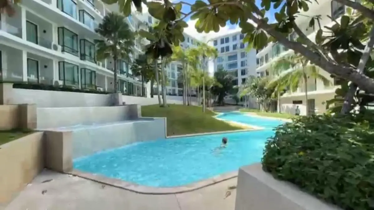 Outdoor Swimming Pool Area with Cascading Water Feature and Tropical Landscaping at Rawai Beach