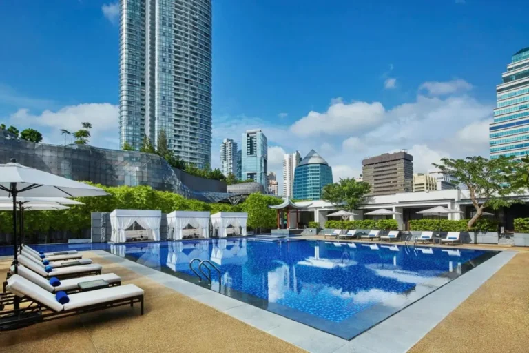 Outdoor Swimming Pool Area with Lounge Chairs and Cabanas in Orchard City Center