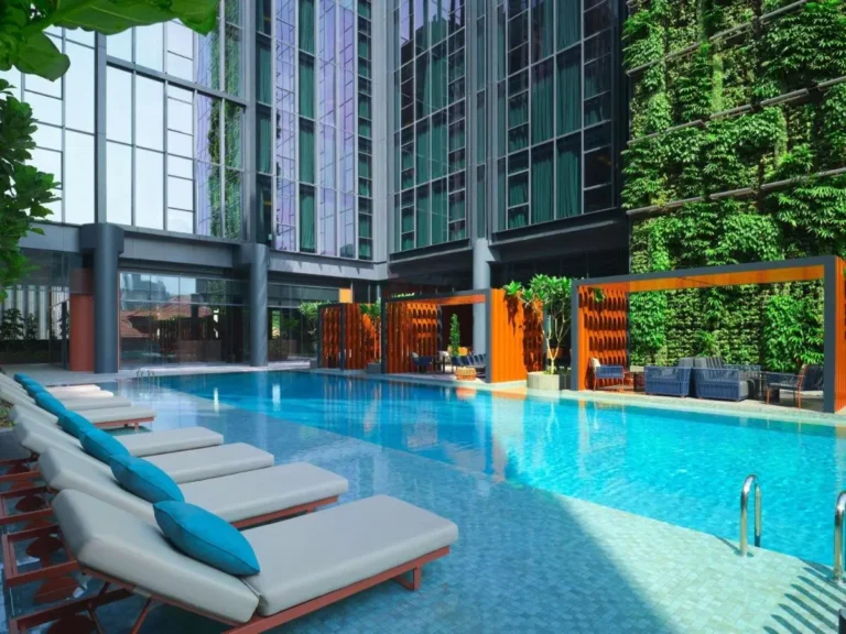 Outdoor Swimming Pool Area with Lounge Chairs and Green Wall in City Hall