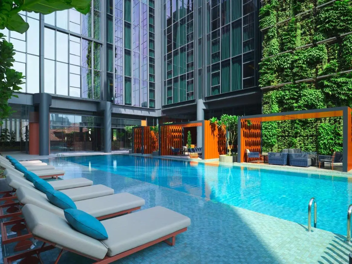 Outdoor Swimming Pool Area with Lounge Chairs and Green Wall in City Hall