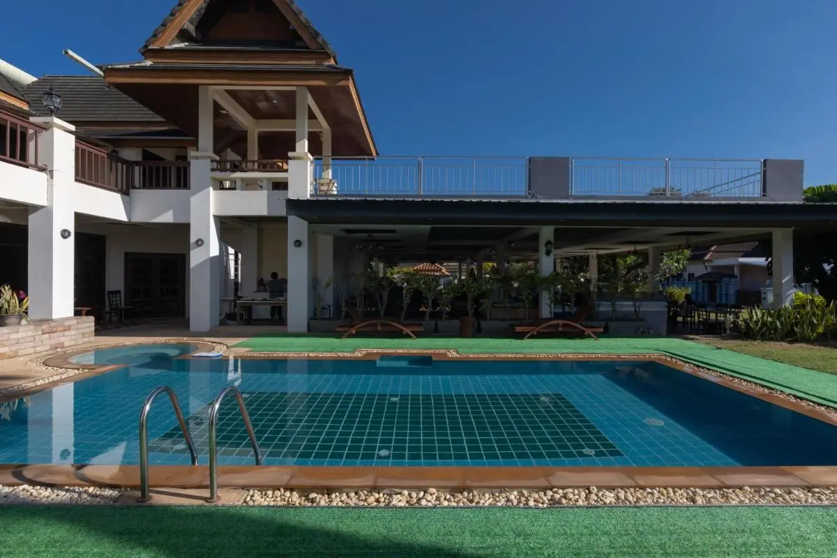 Outdoor Swimming Pool Area with Lounge Chairs and Multi-Level Building at Rawai Beach