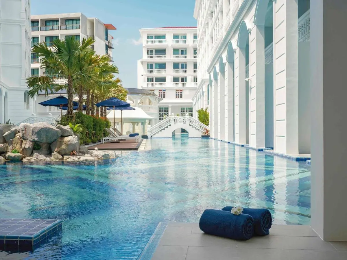Outdoor Swimming Pool Area with Lounge Chairs and Ornamental Bridge at Patong Beach