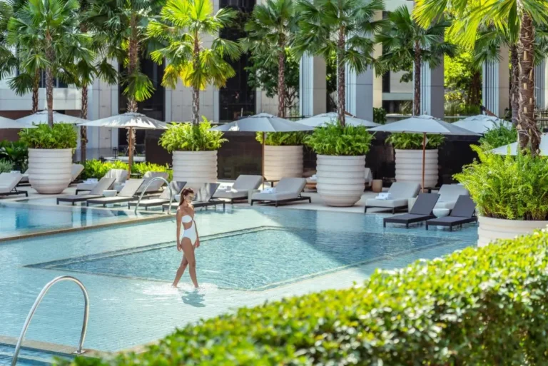 Outdoor Swimming Pool Area with Lounge Chairs and Palm Trees in Sathorn Bangkok