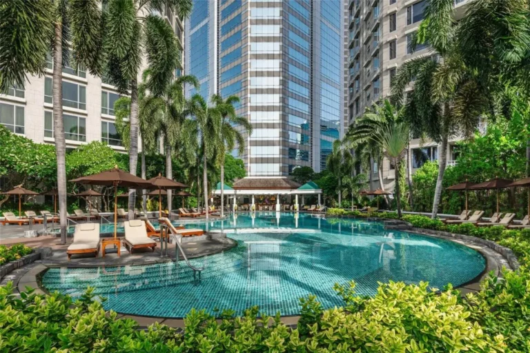Outdoor Swimming Pool Area with Lounge Chairs and Tropical Landscaping in Pathumwan Bangkok