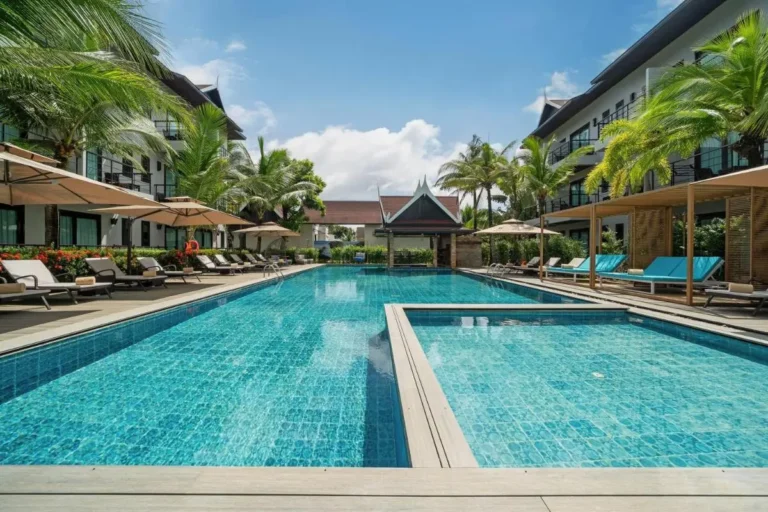 Outdoor Swimming Pool Area with Lounge Chairs and Tropical Landscaping in Thalang