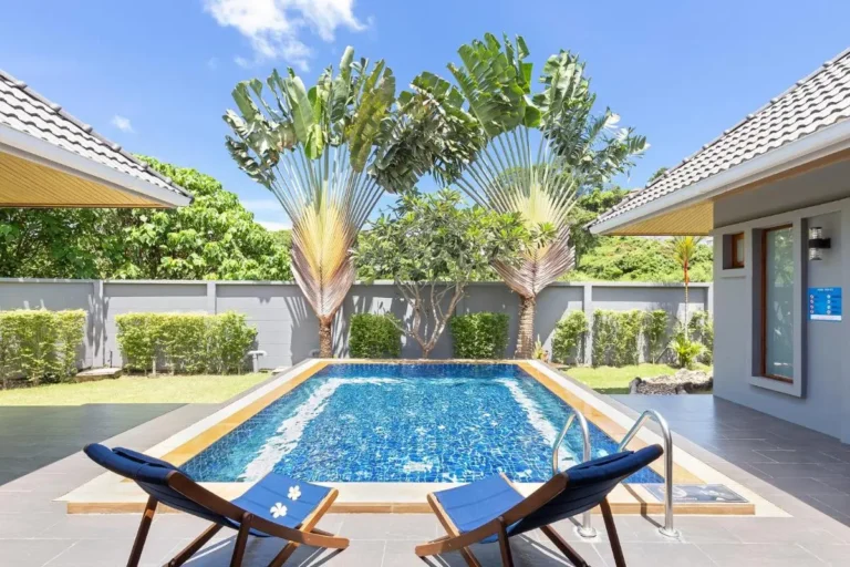 Outdoor Swimming Pool Area with Lounge Chairs and Tropical Plants at Rawai Beach