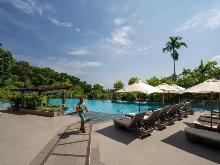 Outdoor Swimming Pool Area with Lounge Chairs and Tropical Surroundings at Patong Beach