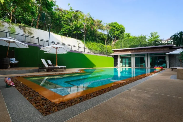 Outdoor Swimming Pool Area with Lounge Chairs and Umbrellas in Ban Bo Rae