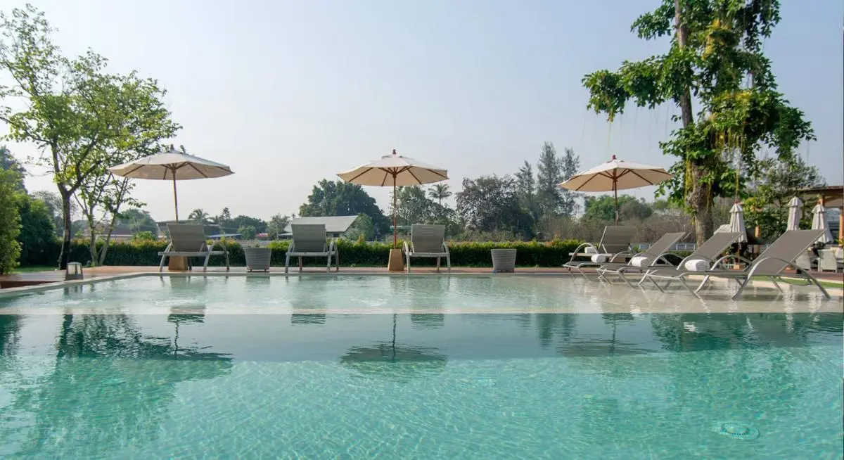 Outdoor Swimming Pool Area with Lounge Chairs and Umbrellas in Chiang Mai