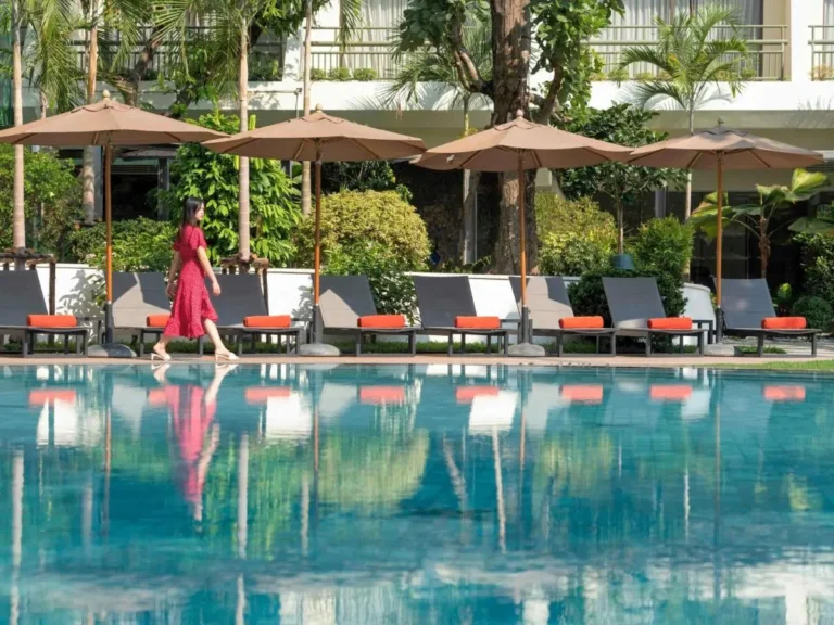 Outdoor Swimming Pool Area with Lounge Chairs and Umbrellas in Pathumwan Bangkok