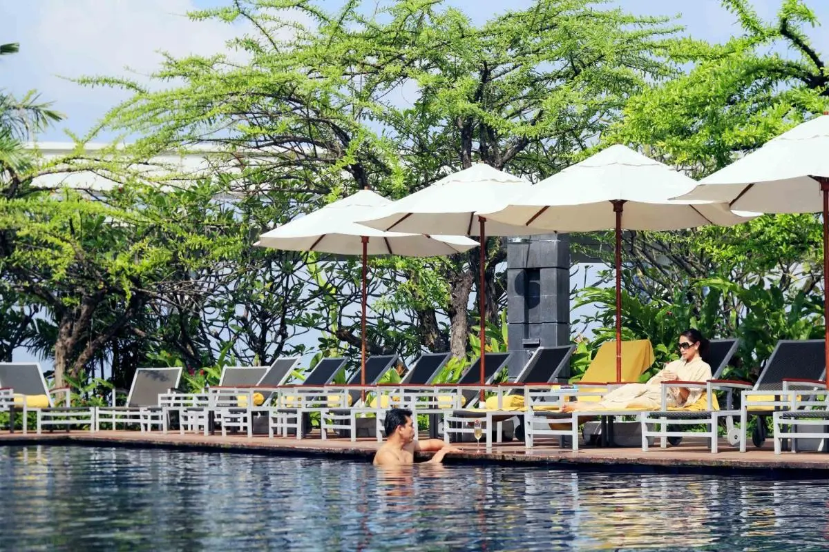 Outdoor Swimming Pool Area with Lounge Chairs and Umbrellas in Pathumwan Bangkok