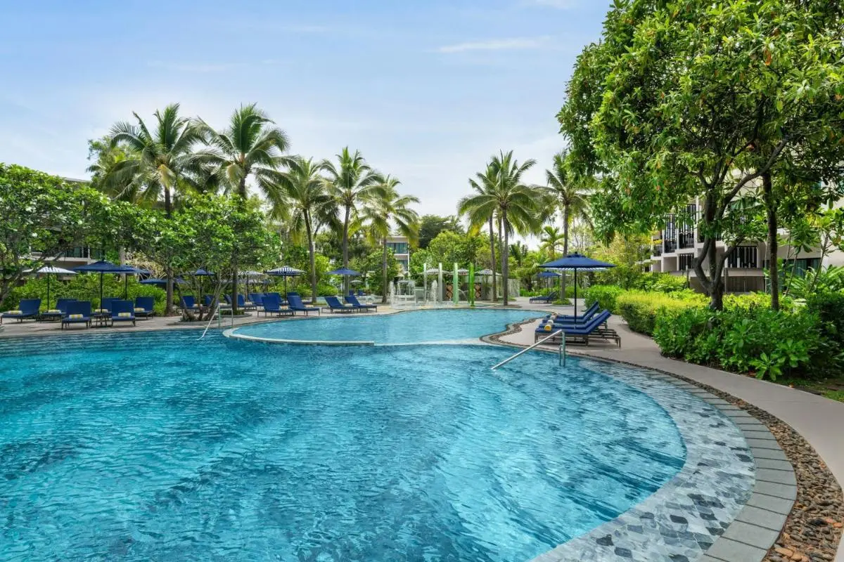 Outdoor Swimming Pool Area with Lounge Chairs and Water Features at Mai Khao Beach