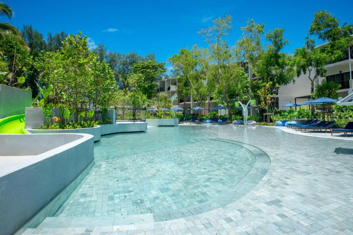 Outdoor Swimming Pool Area with Lounge Chairs and Water Slide at Mai Khao Beach