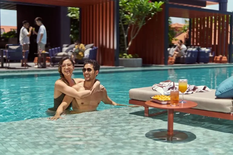 Outdoor Swimming Pool Area with Lounge Seating and Refreshments Near City Hall