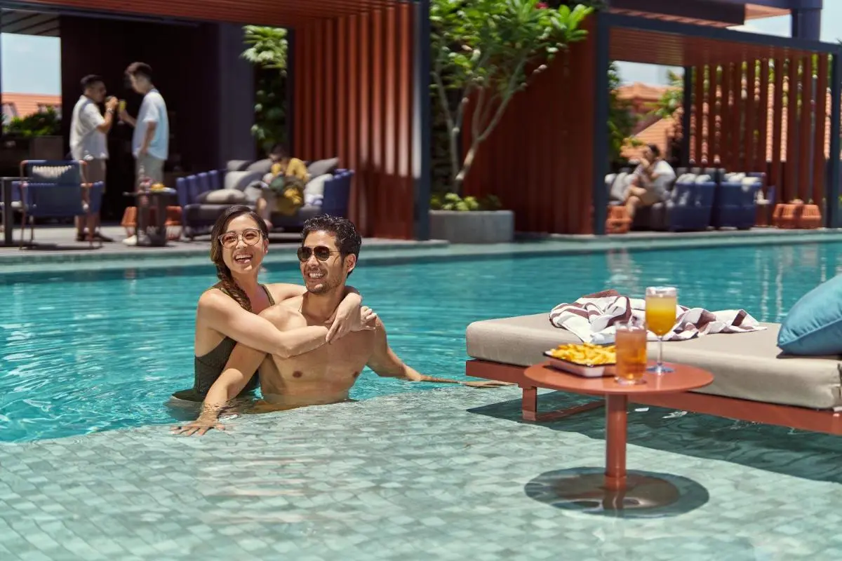 Outdoor Swimming Pool Area with Lounge Seating and Refreshments Near City Hall