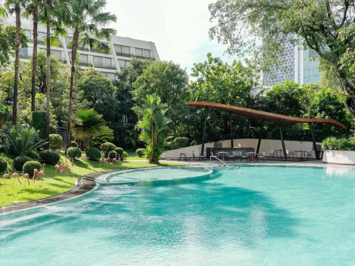 Mövenpick BDMS Wellness Resort Bangkok Outdoor Swimming Pool Area with Tropical Landscaping and Urban Views in Pathumwan Bangkok