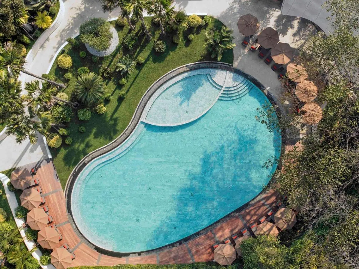 Outdoor Swimming Pool Area with Wooden Deck and Umbrellas in Pathumwan Bangkok