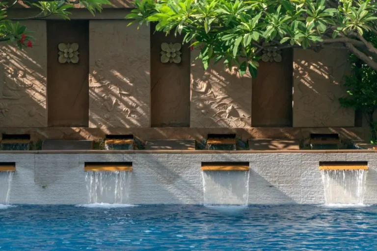 Outdoor Swimming Pool with Decorative Water Spouts and Stone Wall in Ratchathewi Bangkok