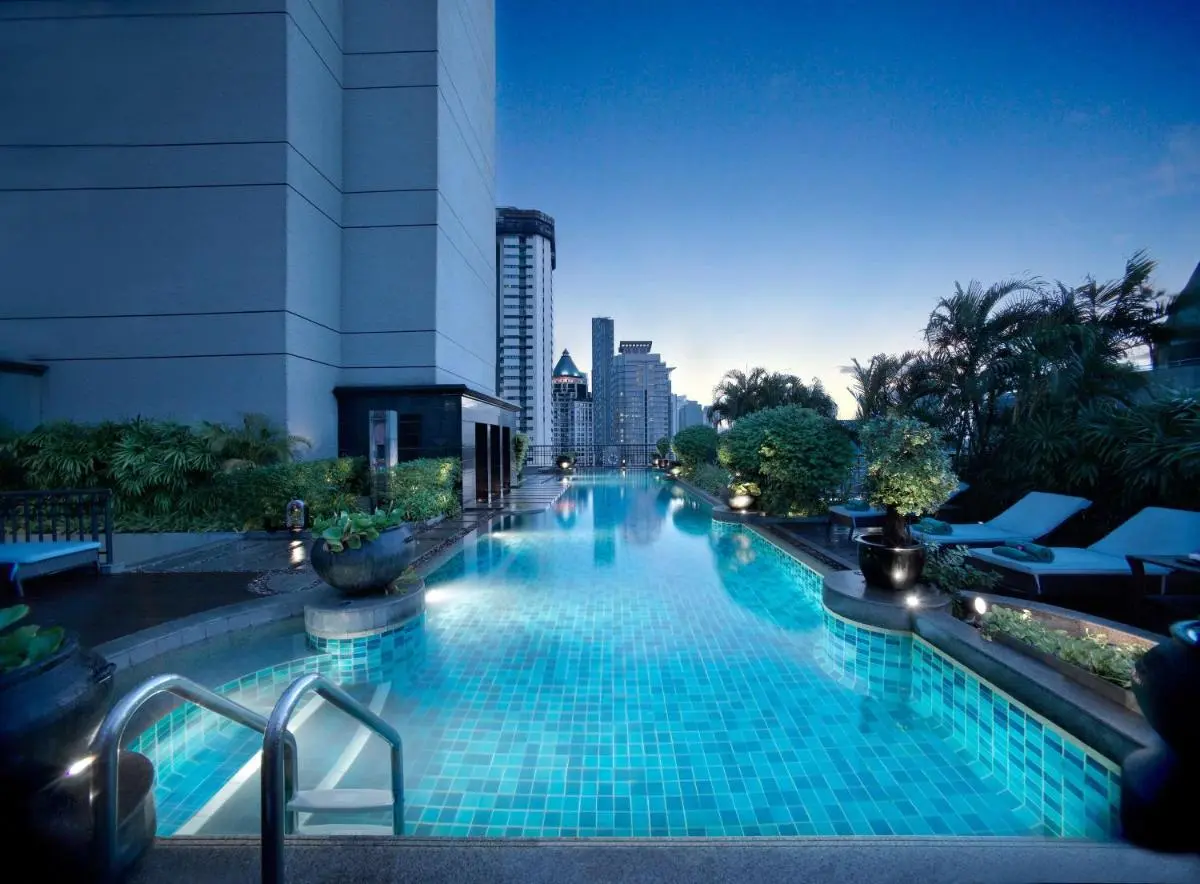 Outdoor Swimming Pool with Lounge Area and Urban Skyline Views in Sathorn Bangkok