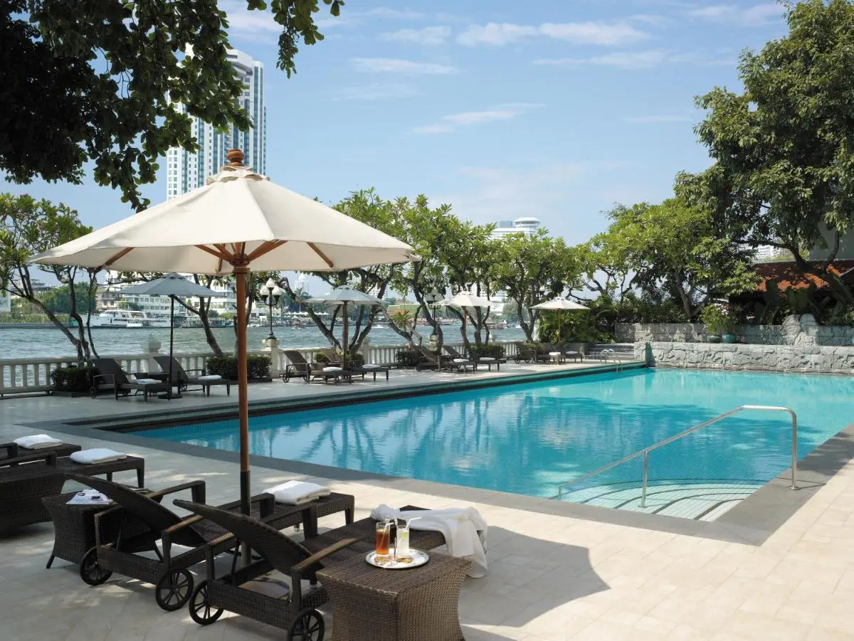 Outdoor Swimming Pool with Lounge Chairs and Scenic Water Views in Bang Rak
