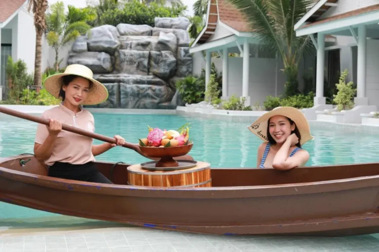 Outdoor Swimming Pool with Waterfall and Wooden Boat in Tropical Thalang Setting