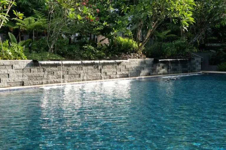 Outdoor Swimming Pool with Waterfall Features and Greenery in Orchard