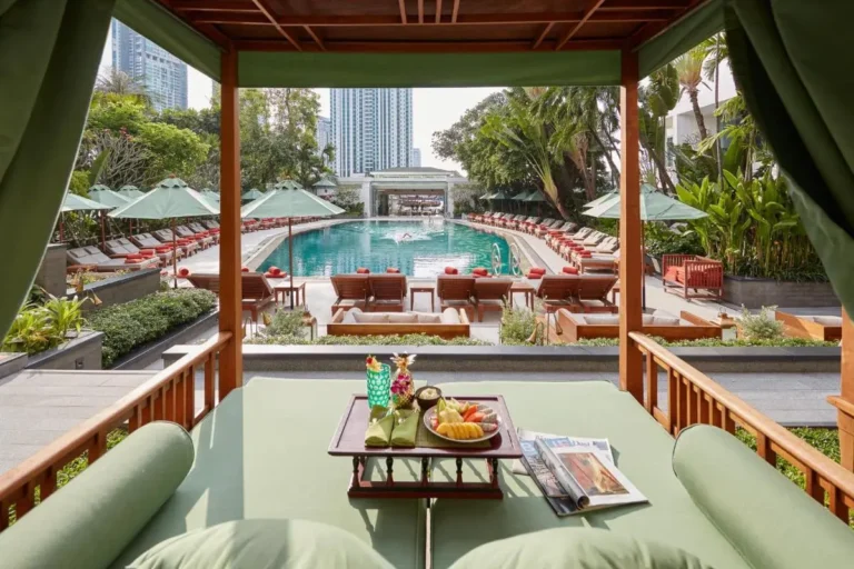 Outdoor Swimming Pool with Wooden Lounge Chairs and Green Umbrellas in Bang Rak