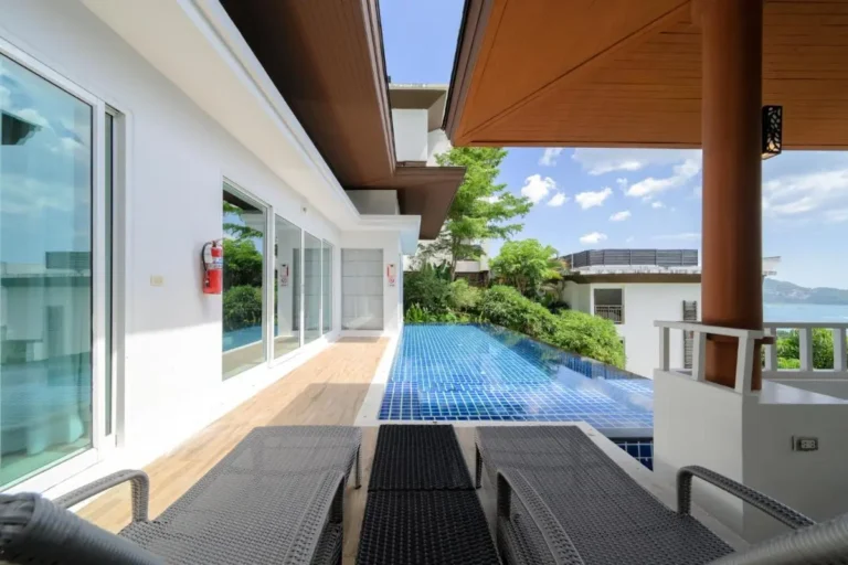 Outdoor Terrace with Infinity Pool and Lounge Chairs Overlooking Scenic Water Views