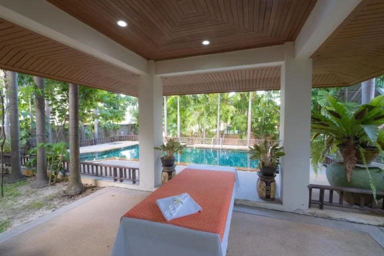 Outdoor Wellness Area with Massage Table and Pool Surrounded by Tropical Plants at Rawai Beach