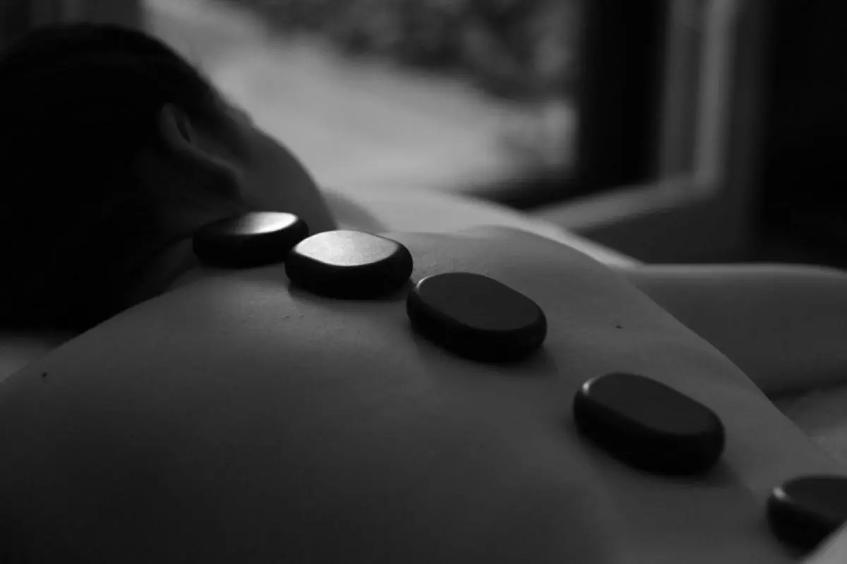 Relaxing Hot Stone Therapy on Upper Back in Pathumwan Spa Setting