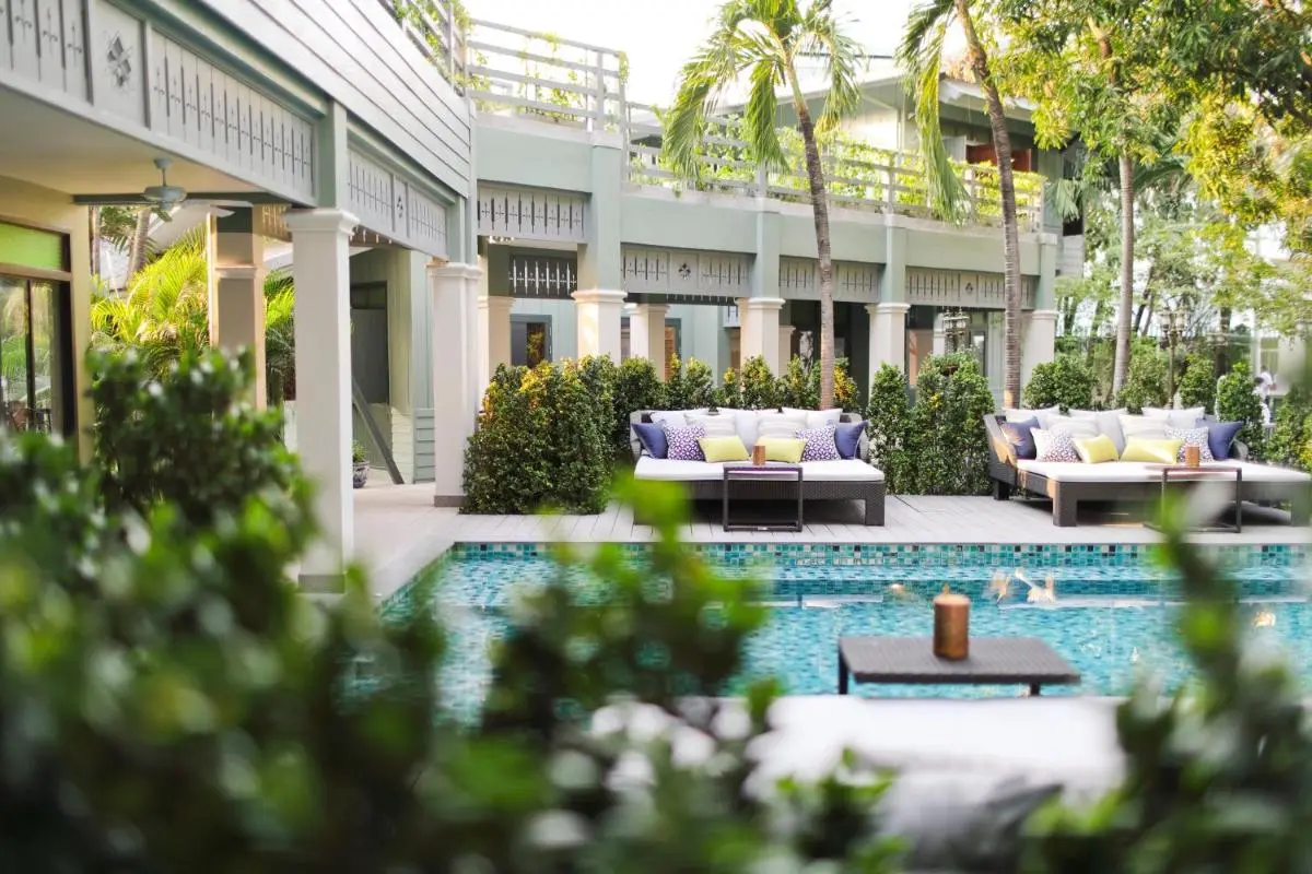 Relaxing Outdoor Pool Area with Lounge Sofas and Tropical Greenery in Phra Nakhon