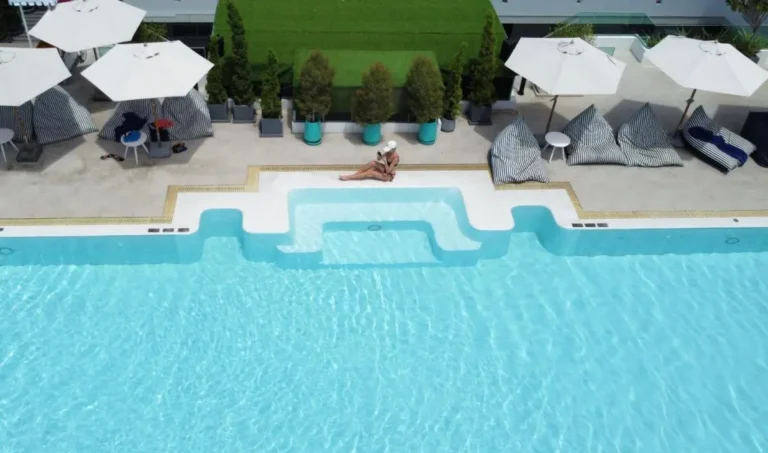 Relaxing Outdoor Swimming Pool Area with Shaded Seating and Greenery at Rawai Beach