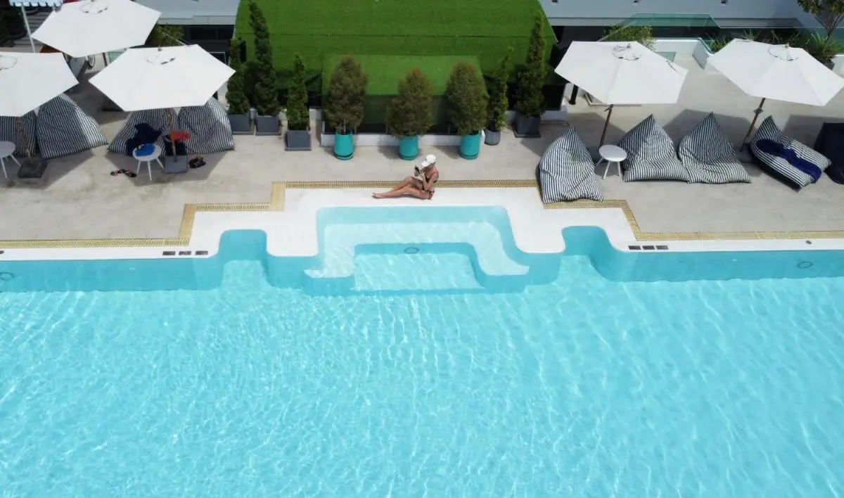 Relaxing Outdoor Swimming Pool Area with Shaded Seating and Greenery at Rawai Beach