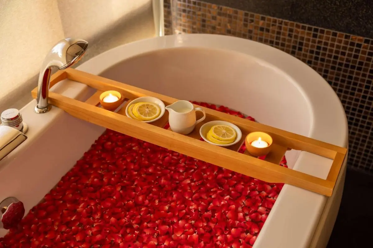 Relaxing Oval Bathtub with Rose Petals and Candlelight in Sathorn Bathroom