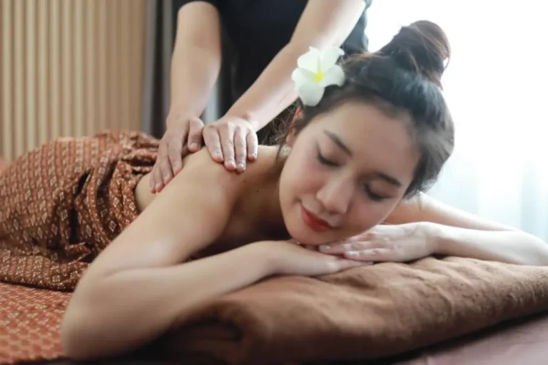 Relaxing Shoulder Massage on a Spa Table with Flower in Hair Thalang