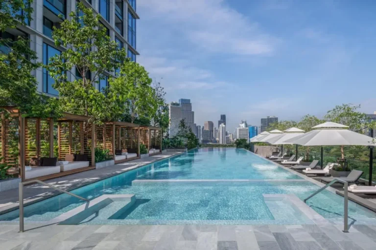Rooftop Infinity Pool with Cabanas and Lounge Chairs Overlooking Bangkok Skyline in Pathumwan