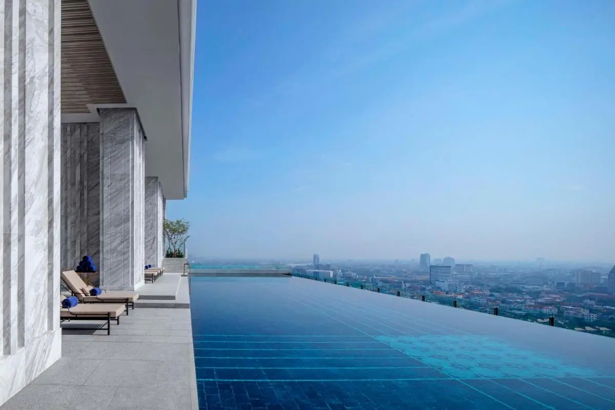 Rooftop Infinity Pool with Cityscape Views and Lounge Area in Wattana Bangkok