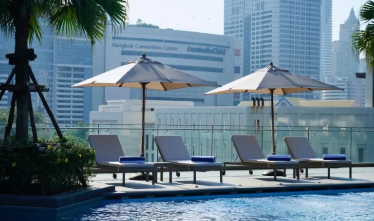 Rooftop Pool Area with Lounge Chairs and City Views in Ratchathewi Bangkok