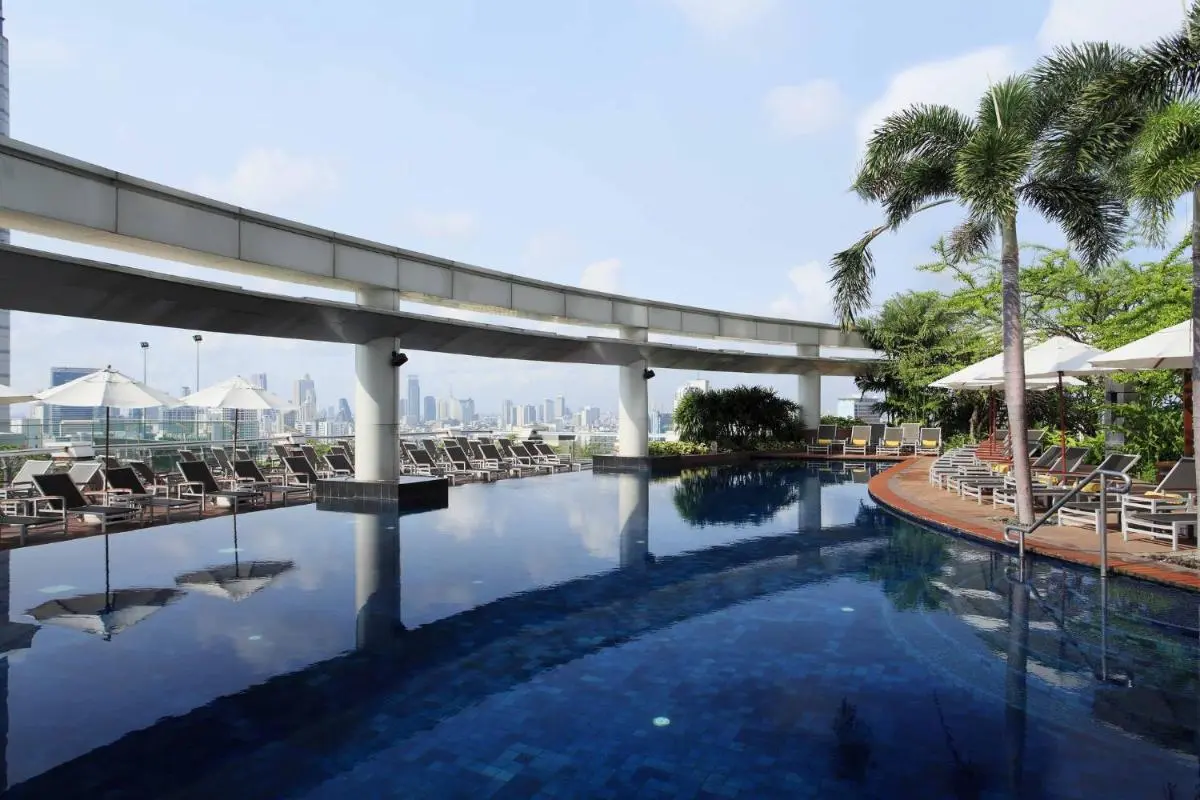 Rooftop Pool Area with Lounge Chairs and Urban Skyline View in Pathumwan Bangkok
