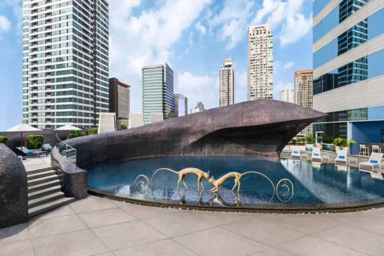 Rooftop Pool with Artistic Sculptures and Urban Skyline Views in Bang Rak Bangkok