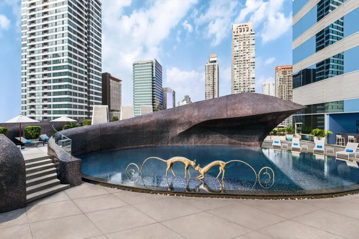 Rooftop Pool with Artistic Sculptures and Urban Skyline Views in Bang Rak Bangkok