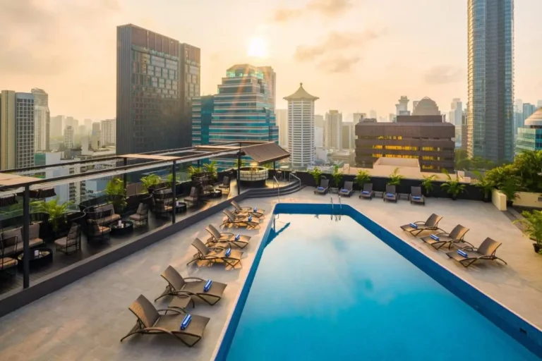 Rooftop Swimming Pool Area with Lounge Chairs and City Views in Orchard
