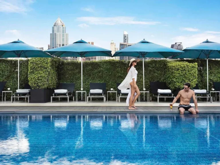 Rooftop Swimming Pool with Lounge Chairs and City Skyline View in Wattana Bangkok