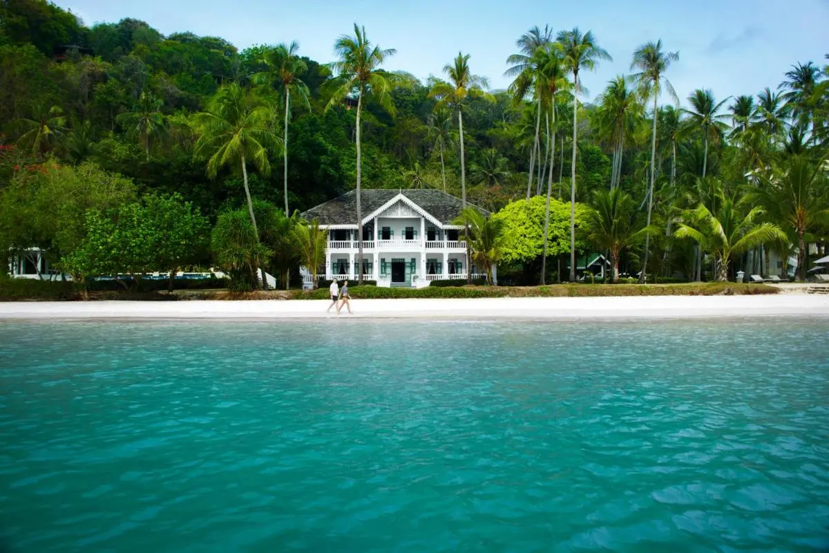Serene Beachfront Scene with Turquoise Waters and White Two-Story Building at Panwa Beach